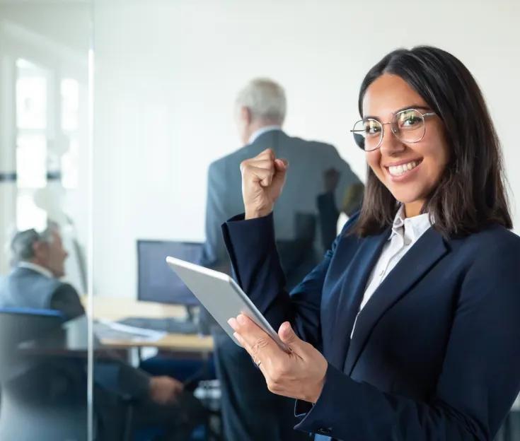 A female professional wearing a suit and a pair glasses and smiling